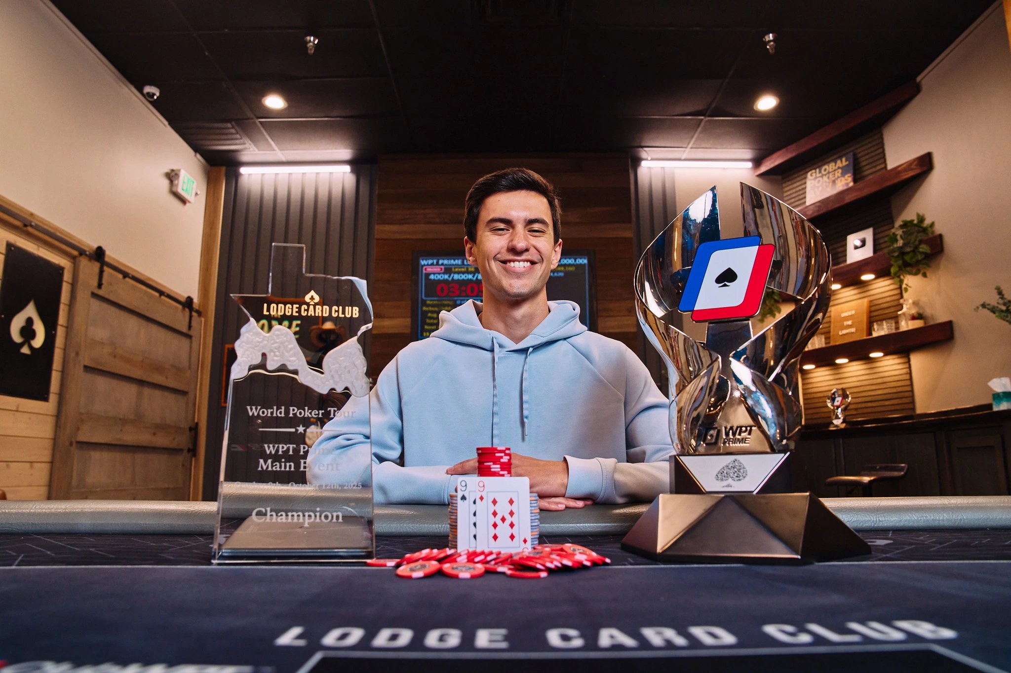 Harvey Castro pictured sitting at the poker table with the WPT Prime Lodge trophy on the right..