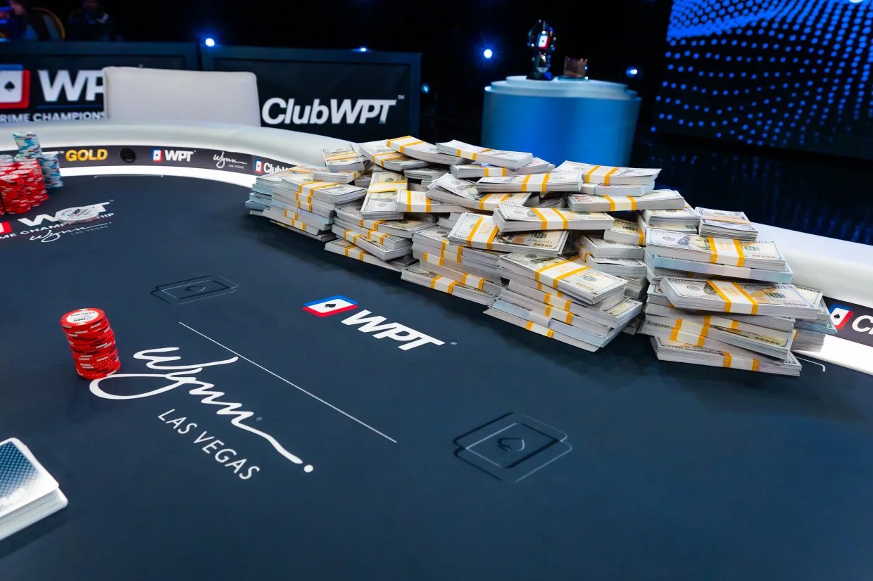 Stacks of $100 bills and chips covering WPT® Prime final table at Wynn Las Vegas.