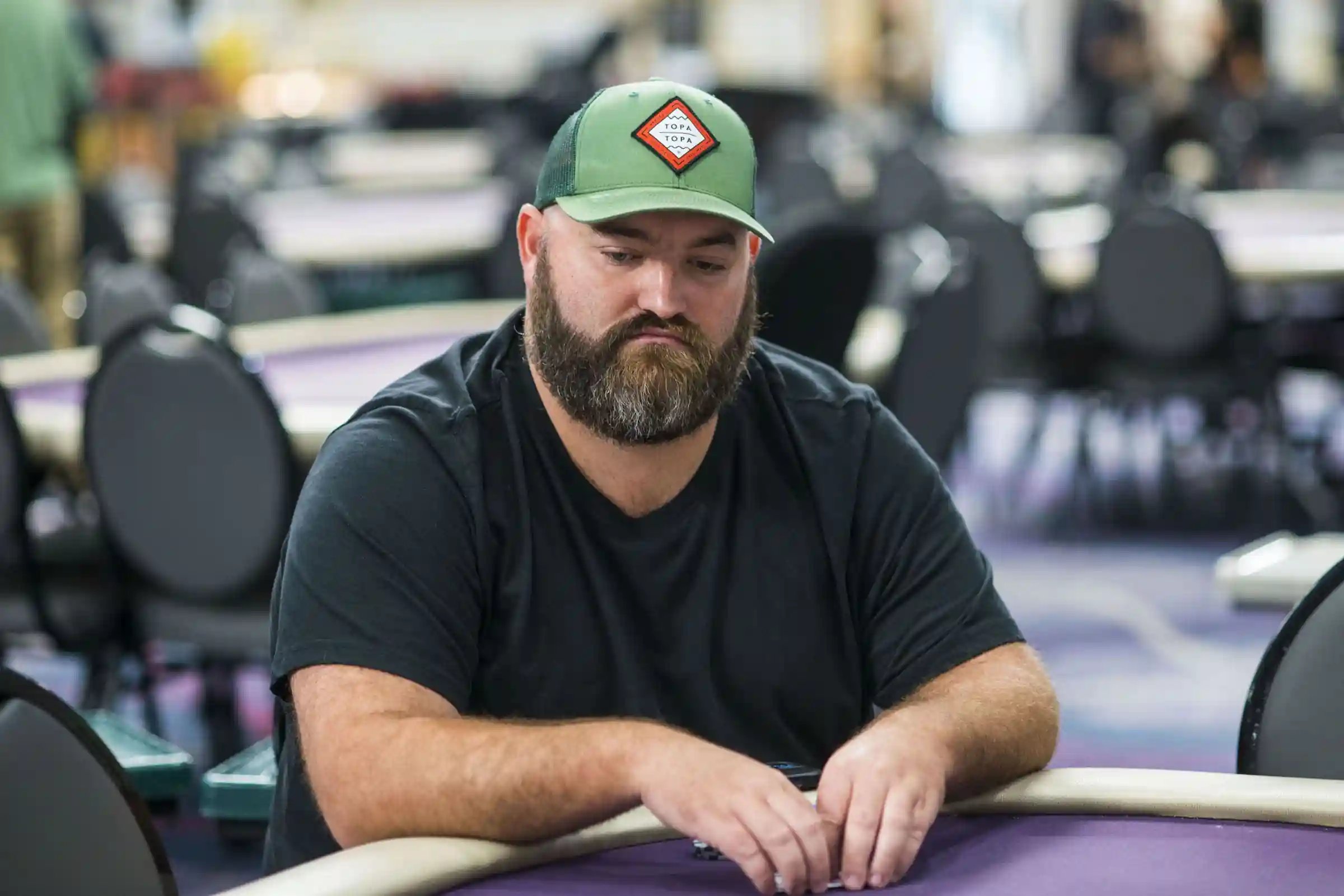 Scott Stewart in green cap stacking chips during WPT® World Championship live tournament.