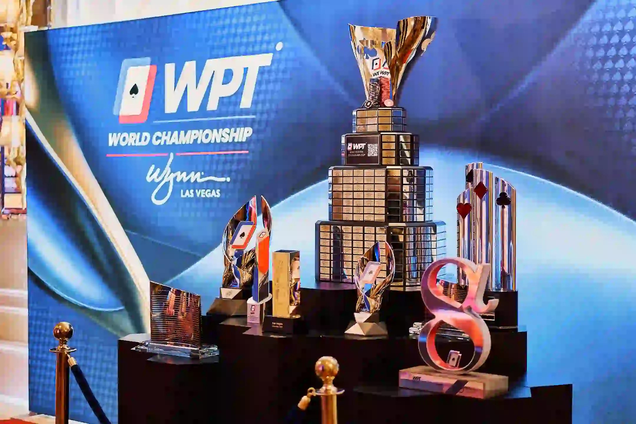 Display of WPT® World Championship trophies and awards in front of branded Wynn Las Vegas backdrop.