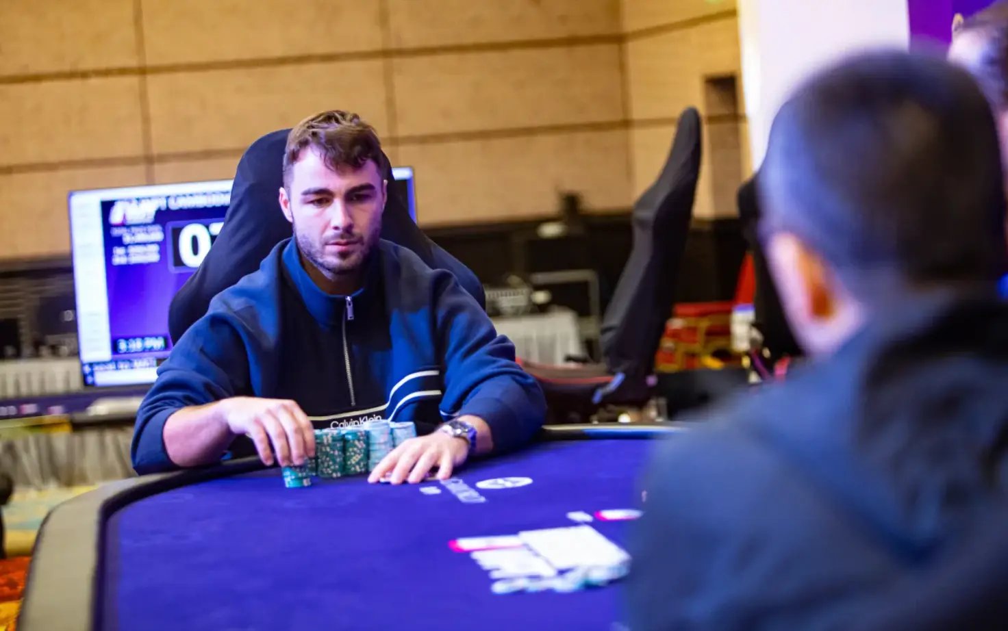 Poker player deep in the WPT Cambodia Championship focused at the final table with a large stack of chips in front of him