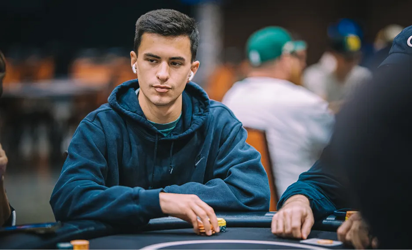 Harvey Castro in a dark hoodie concentrating during a live tournament with chips stacked on the felt in front of him.