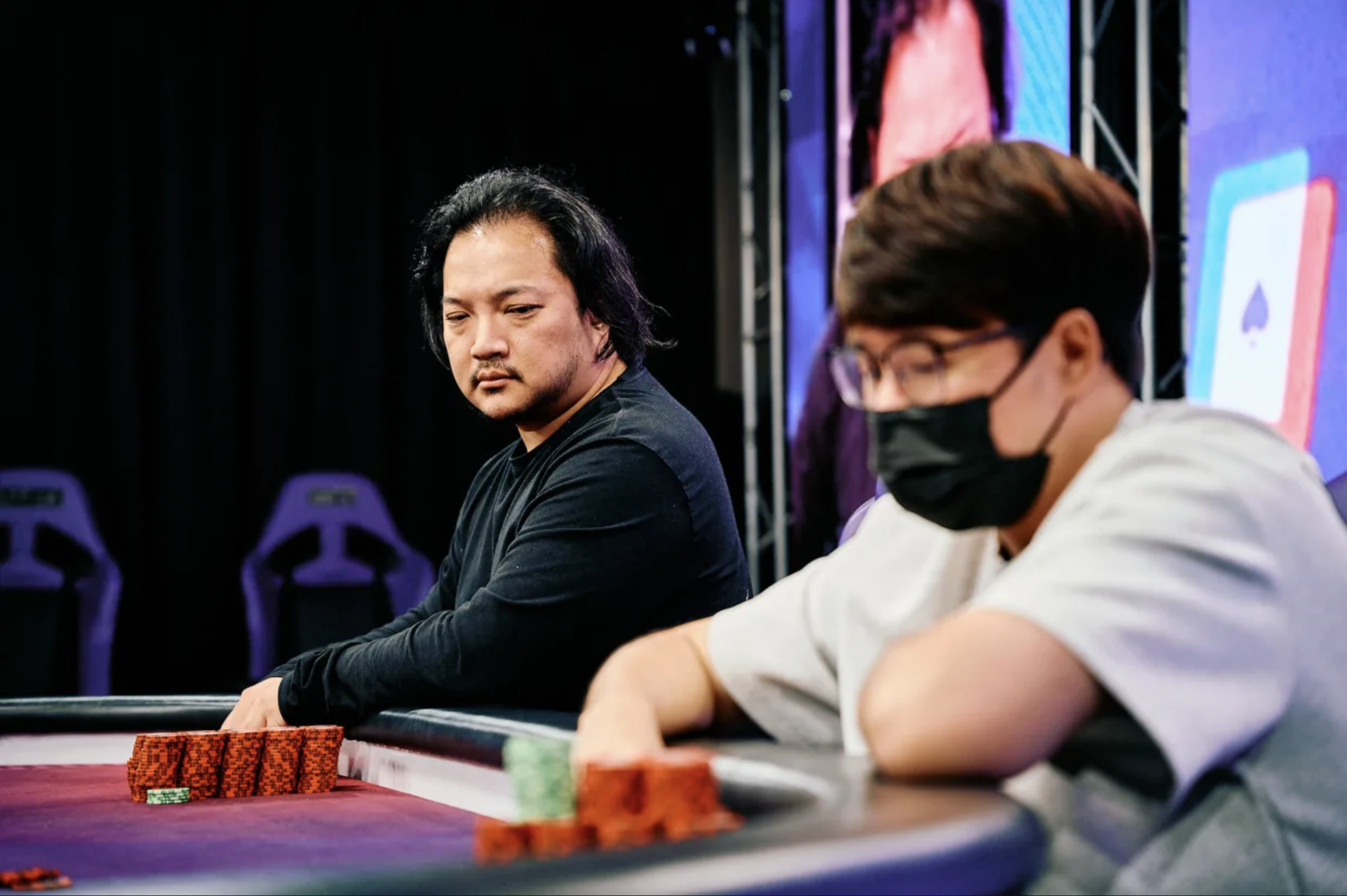 Hyundong Lee and Ci Hong Ho in a tense heads-up moment during a WPT Taiwan tournament, with chips stacked on the table.