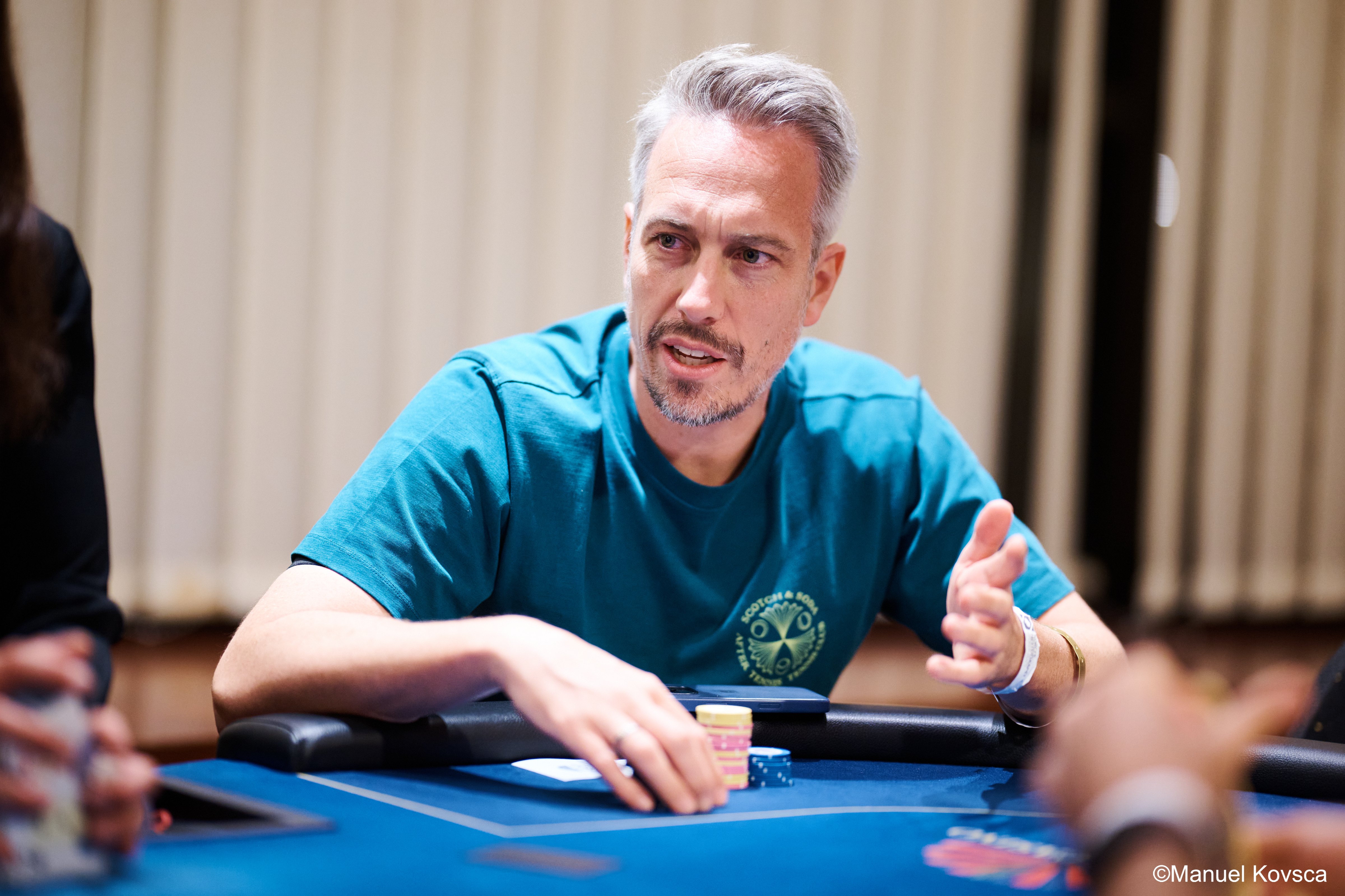 Lex Veldhuis at a blue velvet poker table with chips in hand