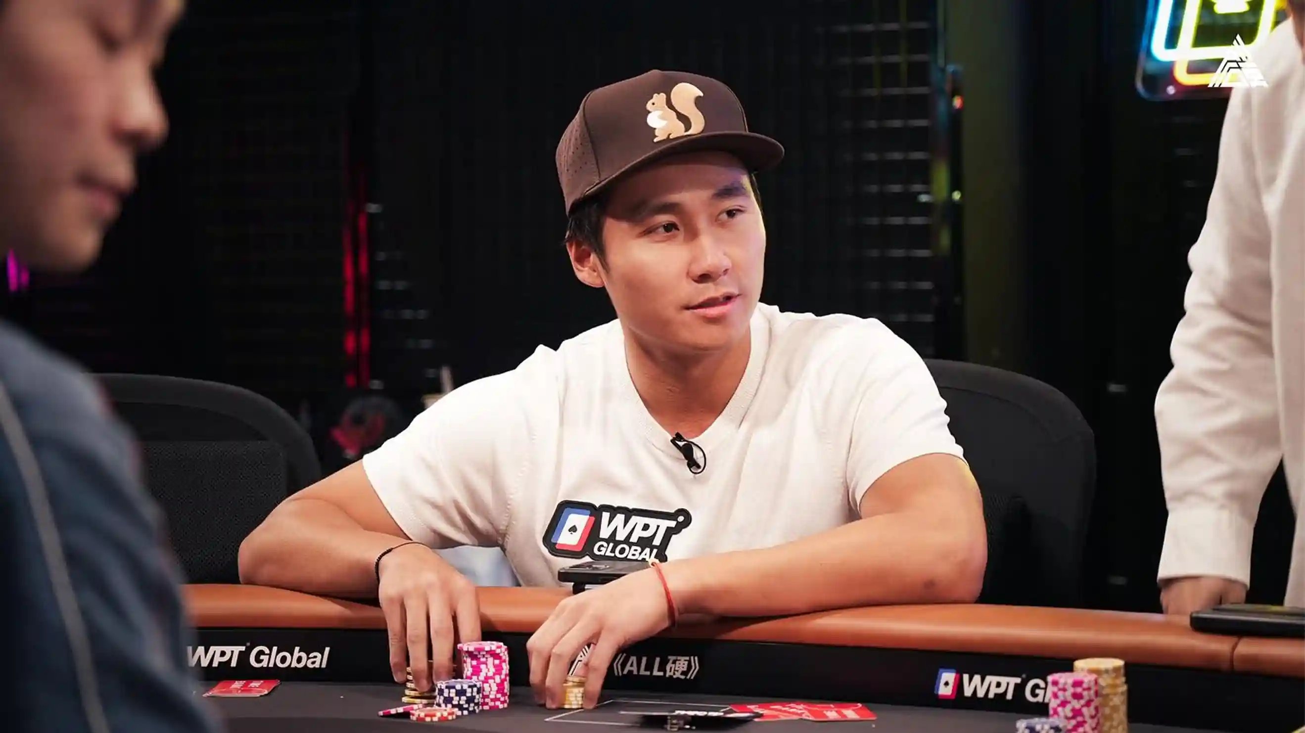 Ethan Yau in a squirrel-logo cap stacking chips at a WPT® Global feature table