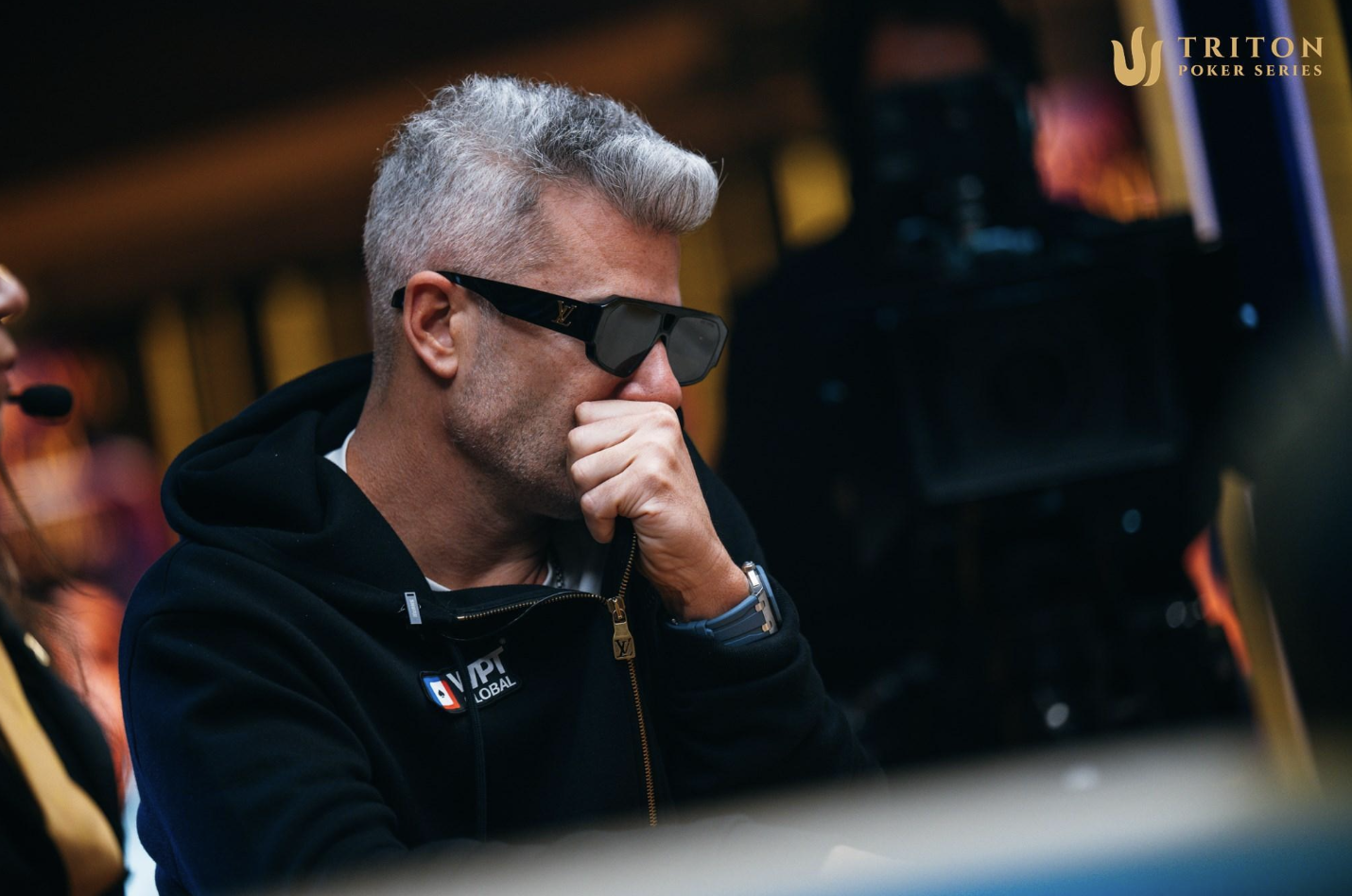Nacho Barbero wearing sunglasses and a WPT Global hoodie focused at the Triton Poker Series table.