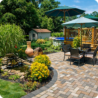Modern backyard with paver patio, retaining wall, lush lawn, and landscaped garden beds.