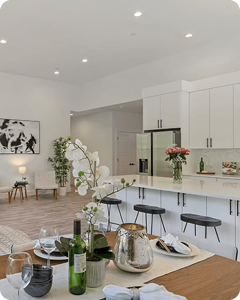 Modern white kitchen with large island and open living space with seating area.