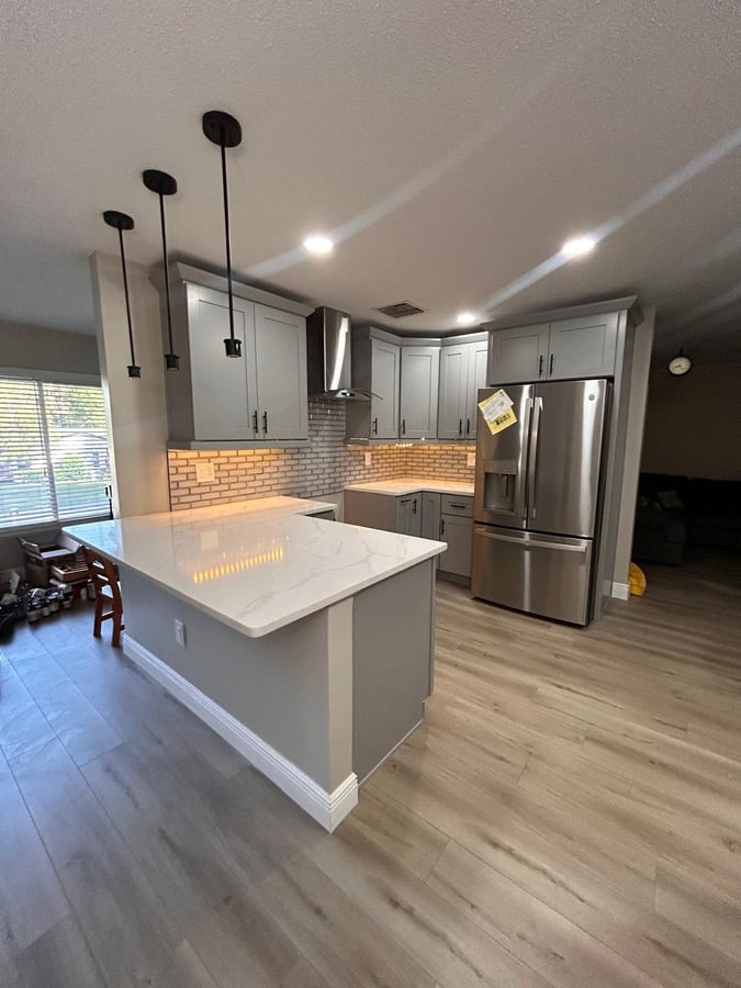 Wekiva kitchen remodel with gray shaker cabinets and quartz peninsula