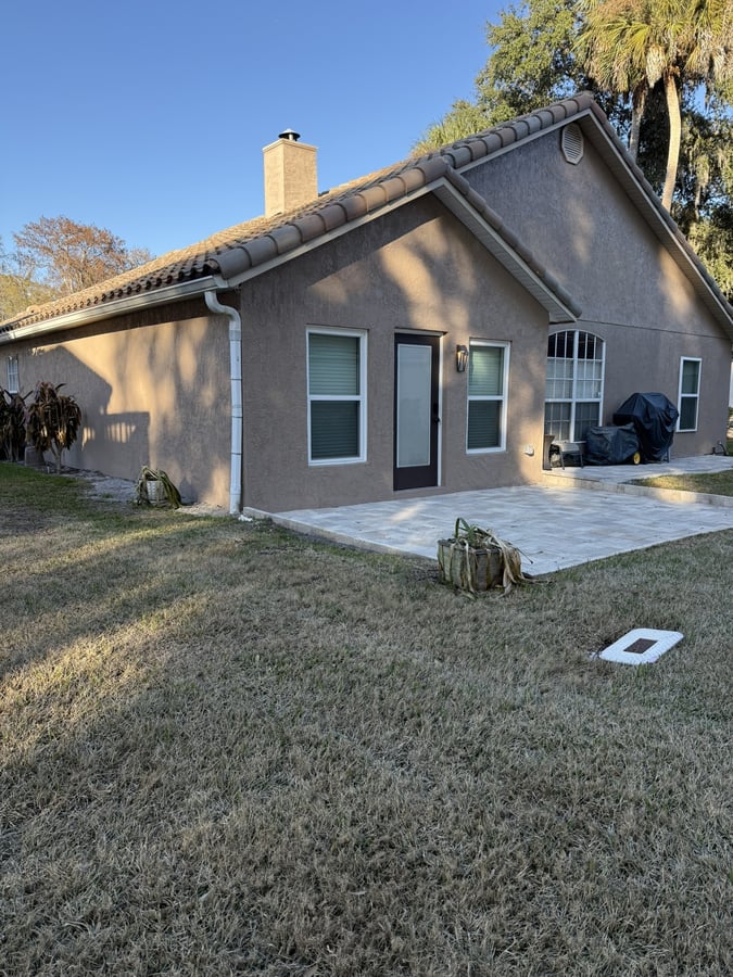 Travertine paver patio and rear exterior at a Winter Springs home