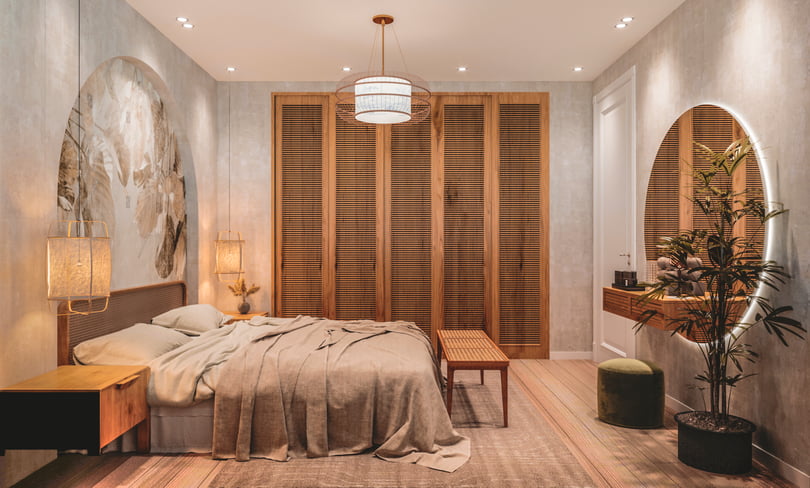 Elegant primary bedroom design in Amsterdam duplex apartment with bespoke headboard wall, integrated bedside tables and natural wood finishes