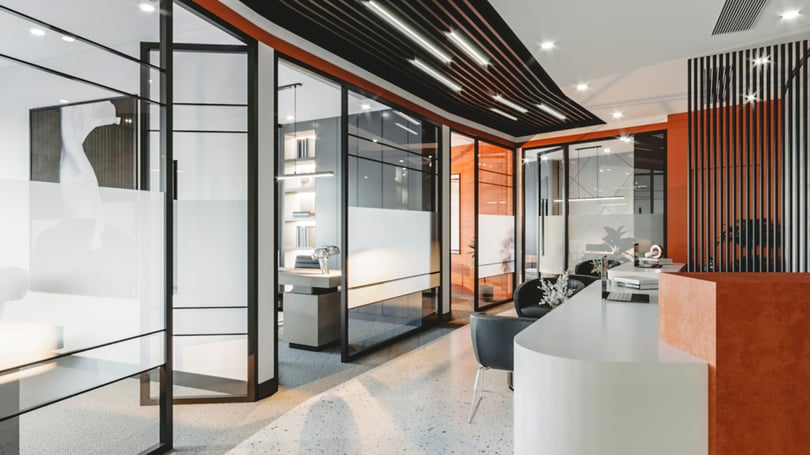 Levent, Istanbul'da cam bölmeler, siyah metal çerçeveler ve dinamik tavan aydınlatma konseptiyle modern kurumsal koridor tasarımı