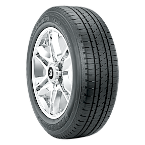 A car tire with a detailed tread pattern is mounted on a shiny alloy wheel against a plain background.