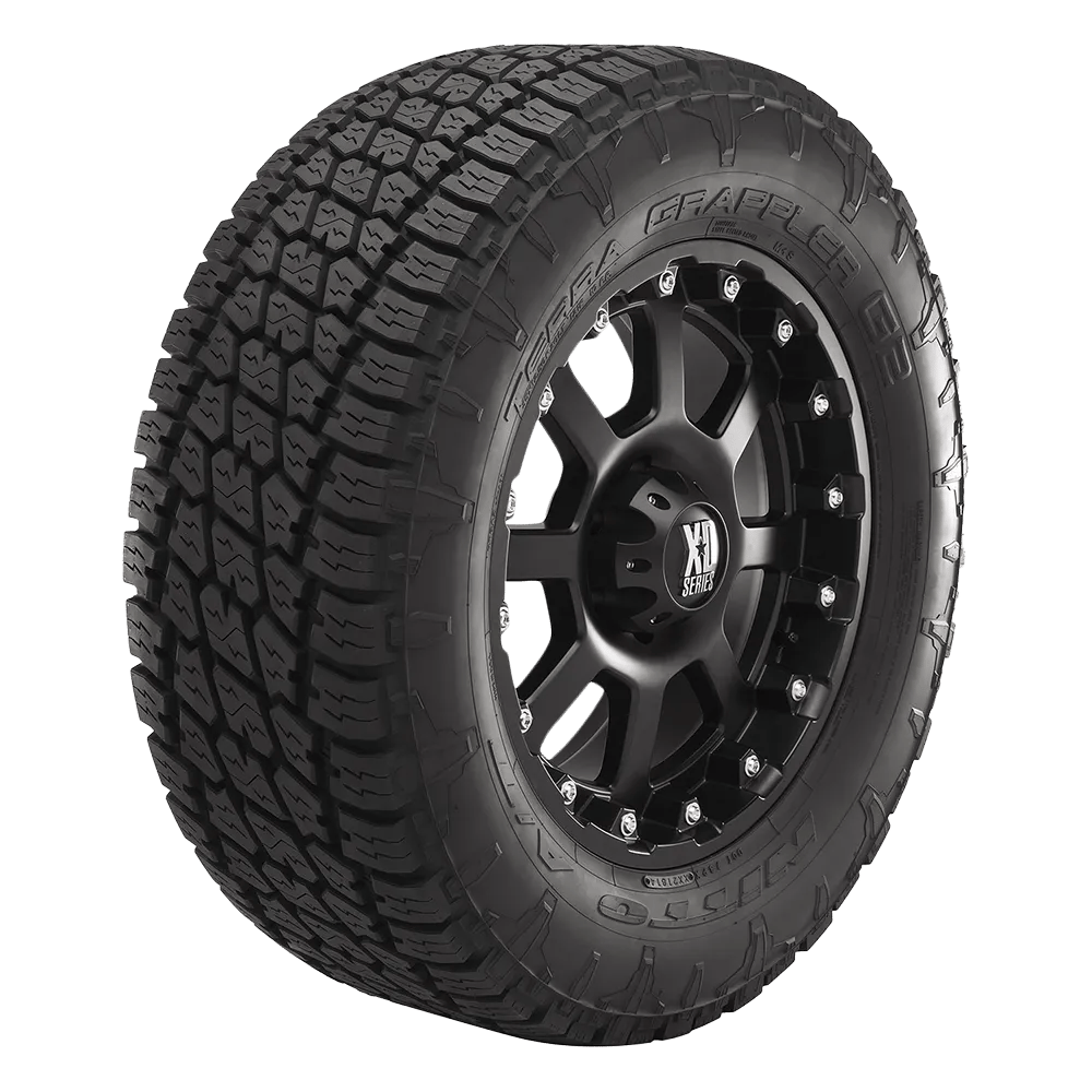 A black Nitto Terra Grappler G2 tire featuring a rugged all-terrain tread pattern and mounted on a black, multi-spoke XD Series wheel with decorative bolts around the rim.