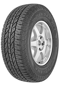 A close-up view of a Yokohama Geolandar H/T G056 tire showcasing its tread pattern and sidewall design, mounted on a silver alloy wheel.