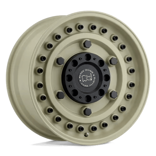 A tan off-road vehicle wheel with a robust design, featuring a black center cap bearing a logo. The wheel is equipped with multiple lug nuts and rivets along the rim for added durability, indicating it's suitable for rugged terrain.