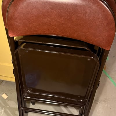 Stacked folding chairs with brown vinyl upholstery - Image 1 of 6