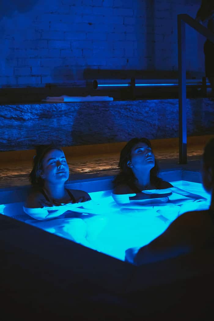 Ambiance nocturne au sein de RECESS — l'espace de bain de glace éclairé sous une lumière bleue profonde.