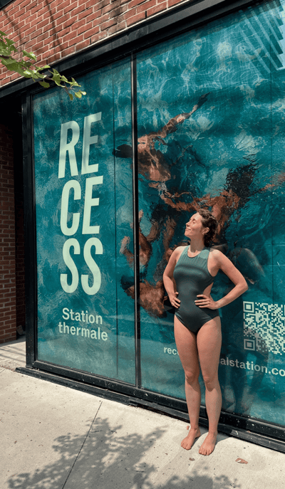 Une personne debout au bord de la mer rocheuse sous un ciel bleu clair