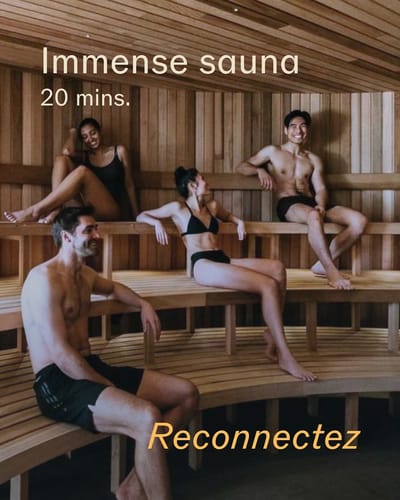 Quatre personnes dans un sauna en bois, assises sur des bancs incurvés