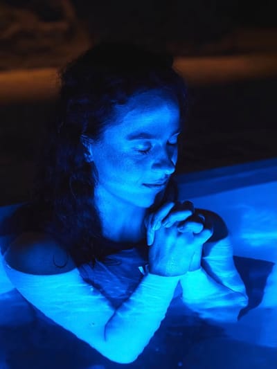 Invitée au repos dans un bassin à lumière bleue, les yeux fermés
