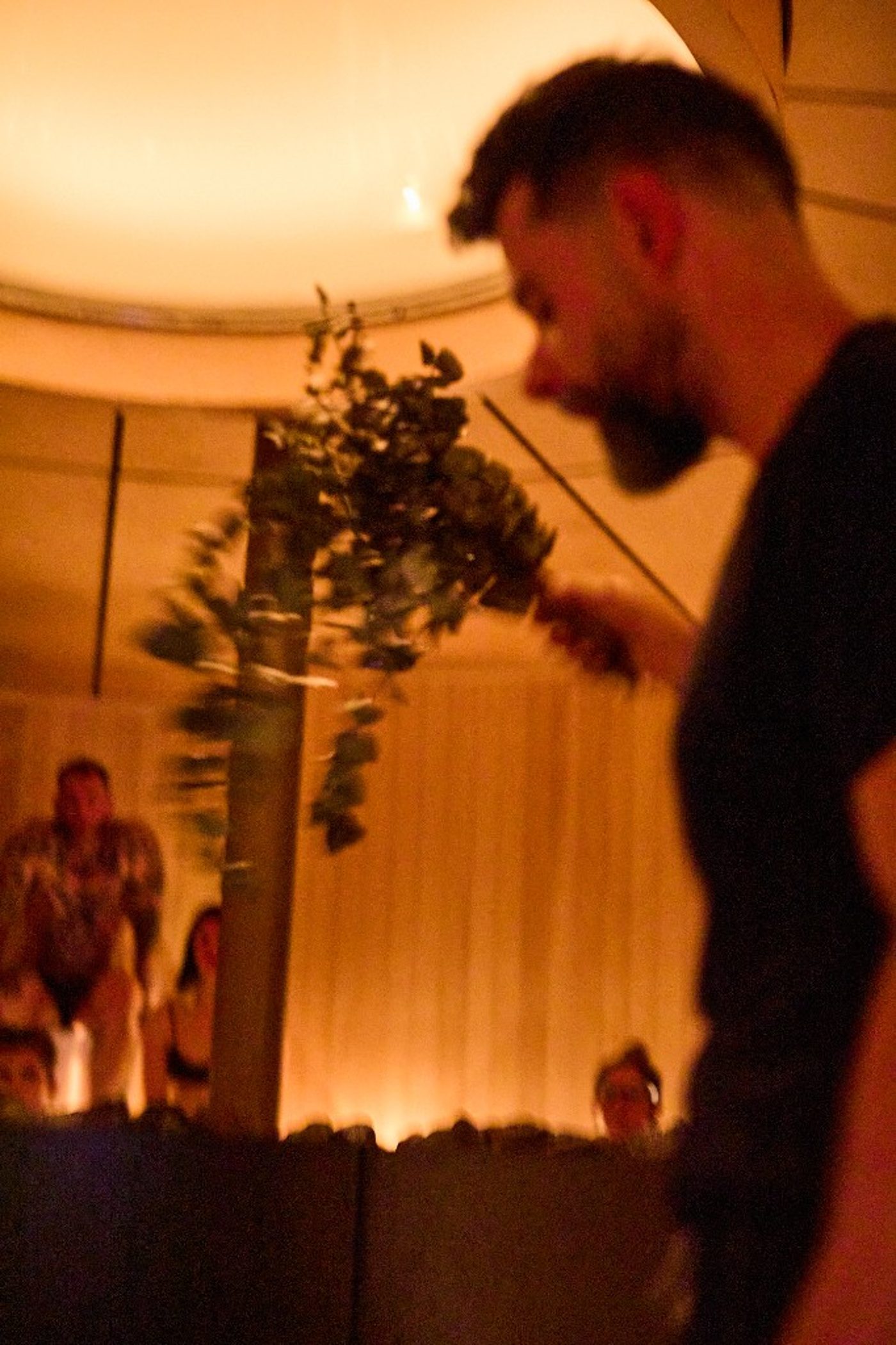 Rituel Badstu au RECESS — branches de bouleau au-dessus des pierres du poêle, chaleur ambrée.