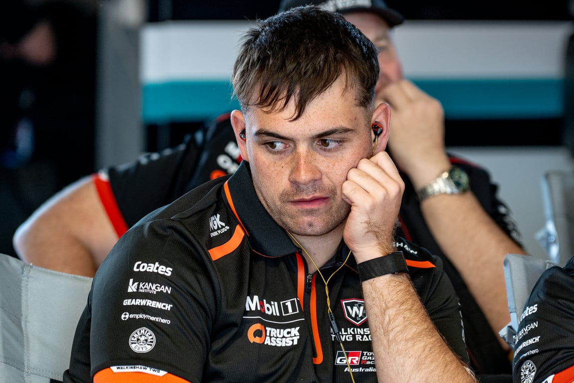 Driver Ryan Wood in black Walkinshaw TWG Racing team shirt rests his chin on his hand in the garage.