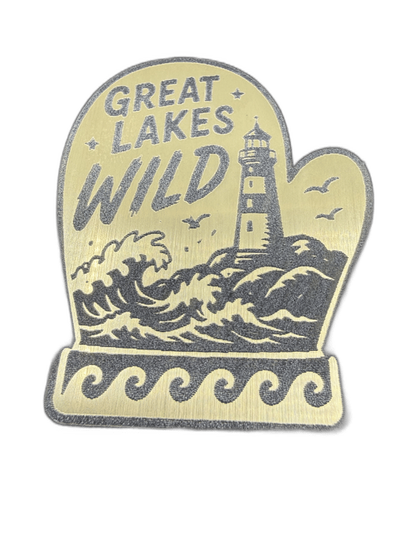 Great Lakes Wild mitten-shaped silver emblem with lighthouse and crashing waves