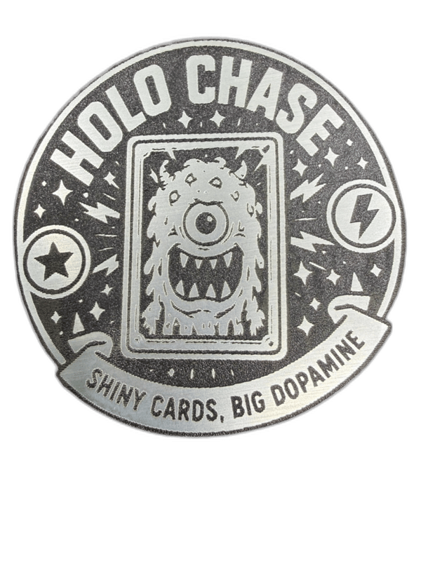 Holo Chase circular silver brushed-metal emblem with one-eyed monster card design and lightning bolts