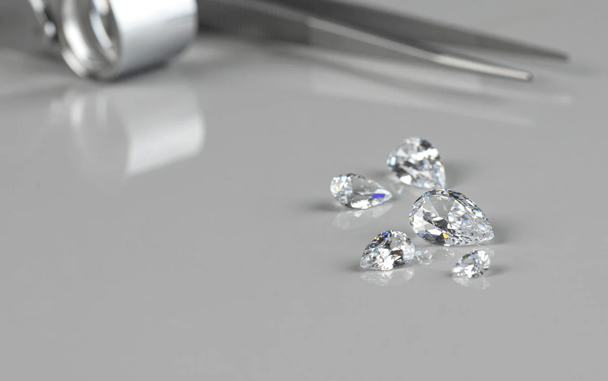 A single round brilliant lab-grown diamond on white marble displaying fire and brilliance in natural light