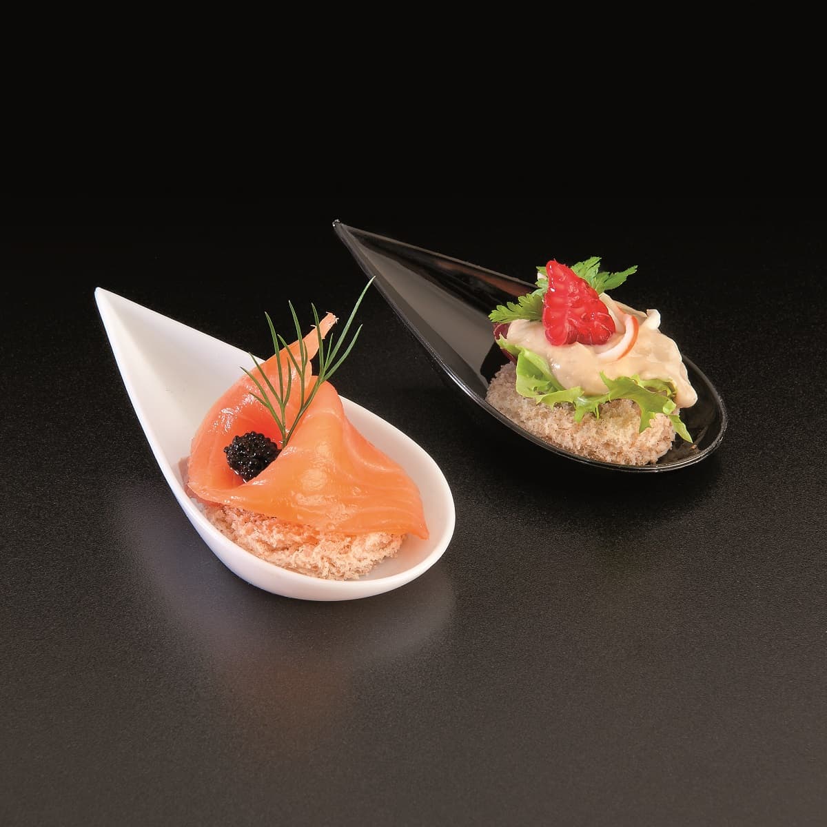 Cucchiaini a goccia bianchi e neri con canapè
