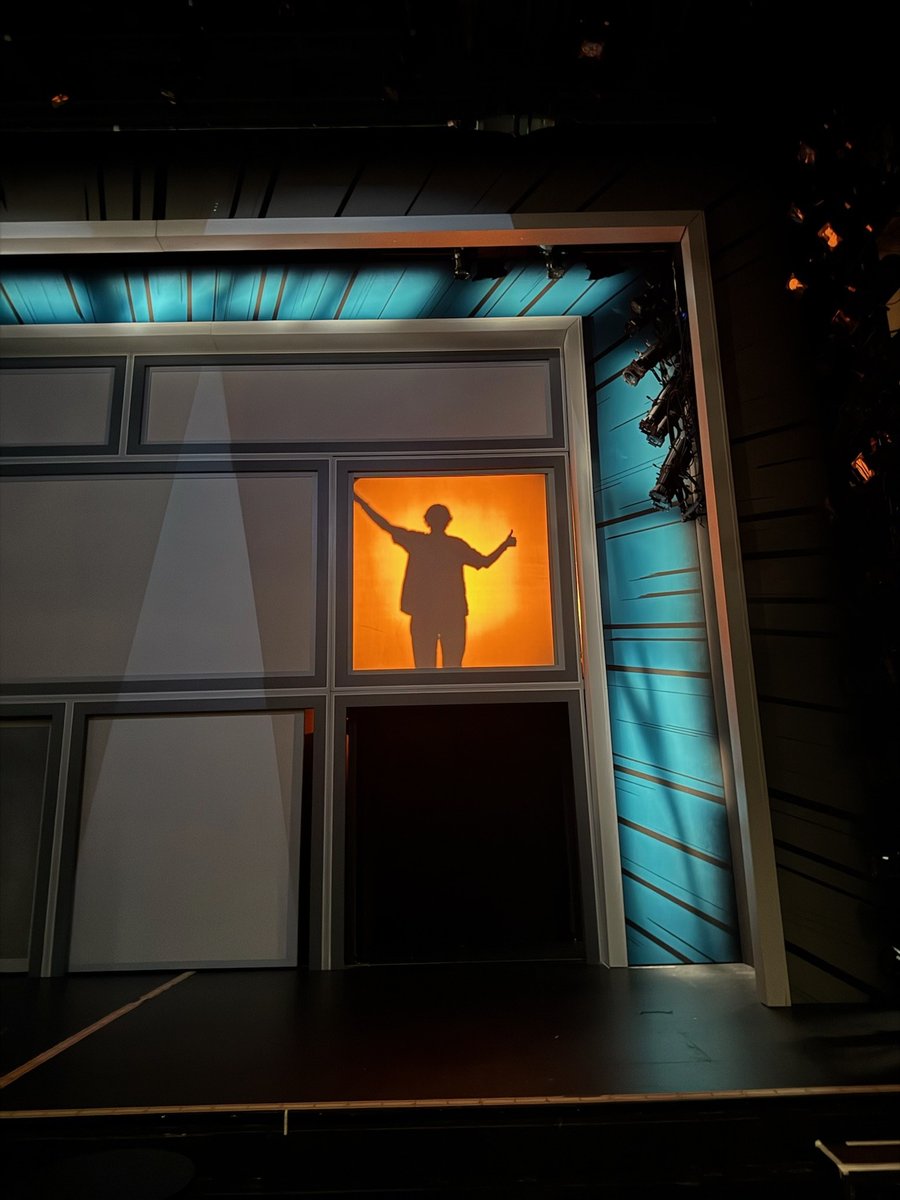 A silhouetted figure stands in a glowing orange doorway on the set during a focus session.