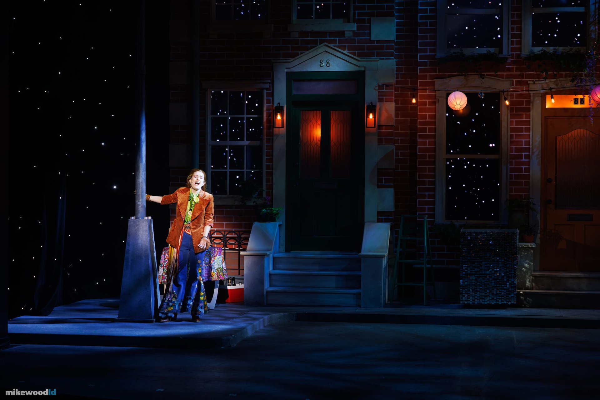 A performer at a lamppost on the moonlit block-party street set in Dancin' In The Street.