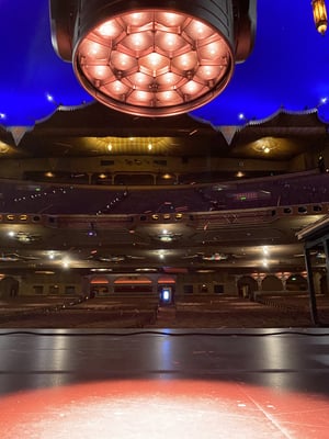 The Fox Theatre Atlanta auditorium seen from the stage, its atmospheric ceiling lit deep blue, with an LED wash light in the foreground