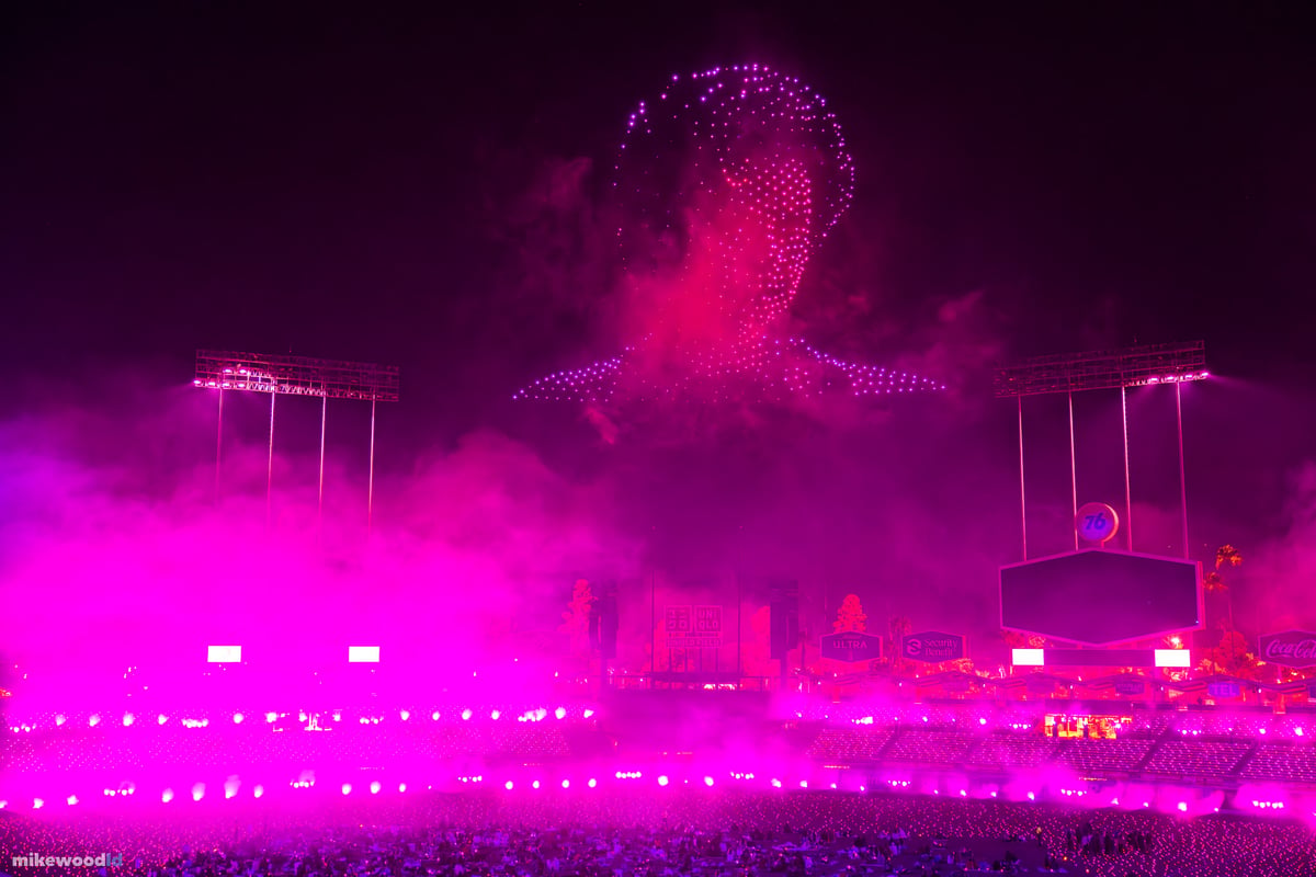 A creature rendered in magenta drones emerging from thick pink haze, the lower bowl saturated in matching pink light.
