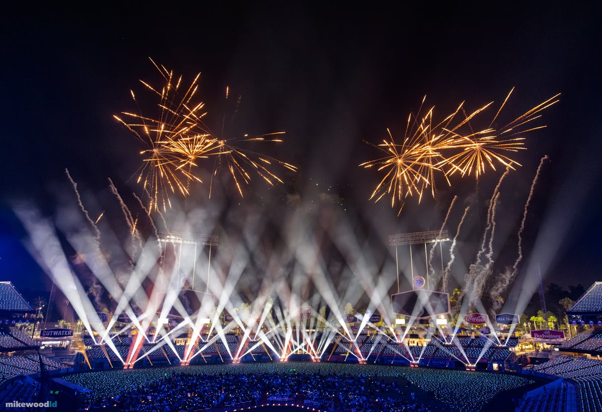 Gold fireworks and rising sparks fill the sky above Dodger Stadium as white beams fan up from the stage in the finale.
