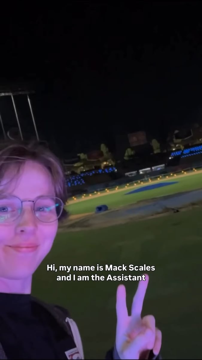 Mack Scales on the field at Dodger Stadium at night, with the lit drone-show rig glowing behind her