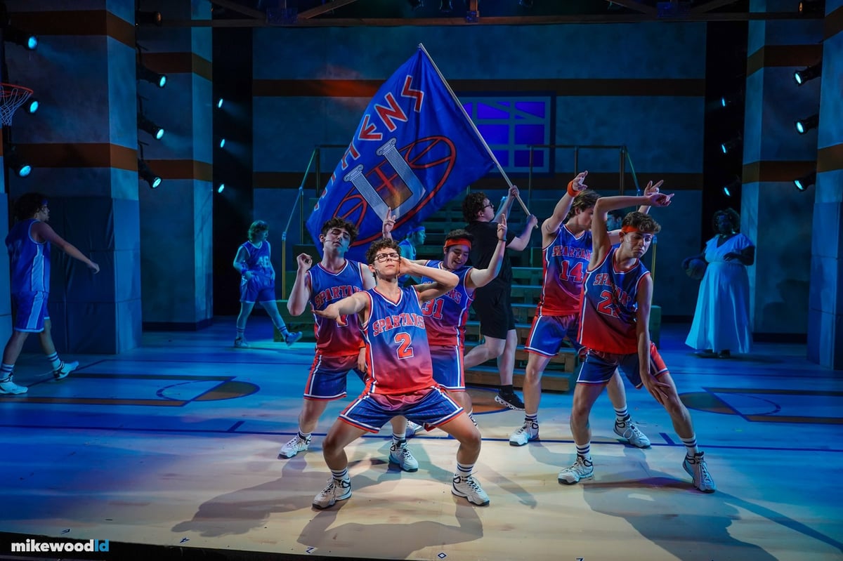 Lysistrata Jones, visible fixture noses through the wings, evocative of stadium lighting arrays.