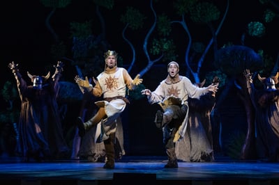 King Arthur and Patsy skip through the forest with horned knights behind them in Monty Python's Spamalot at City Springs Theatre