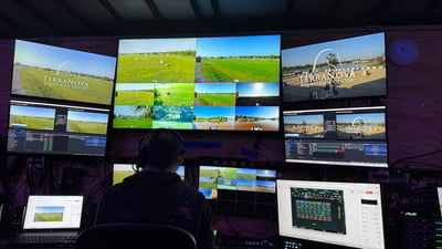 The trailer control room during a show: three large monitors carrying TerraNova-branded program, multiview, and camera feeds, an operator in a headset at the desk.