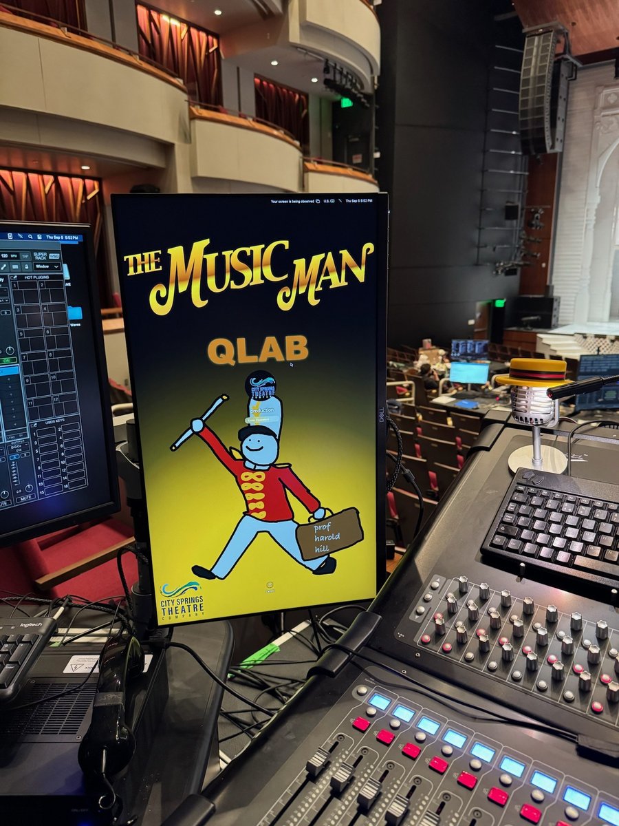A Music Man QLab poster propped at the show-control and lighting tables.