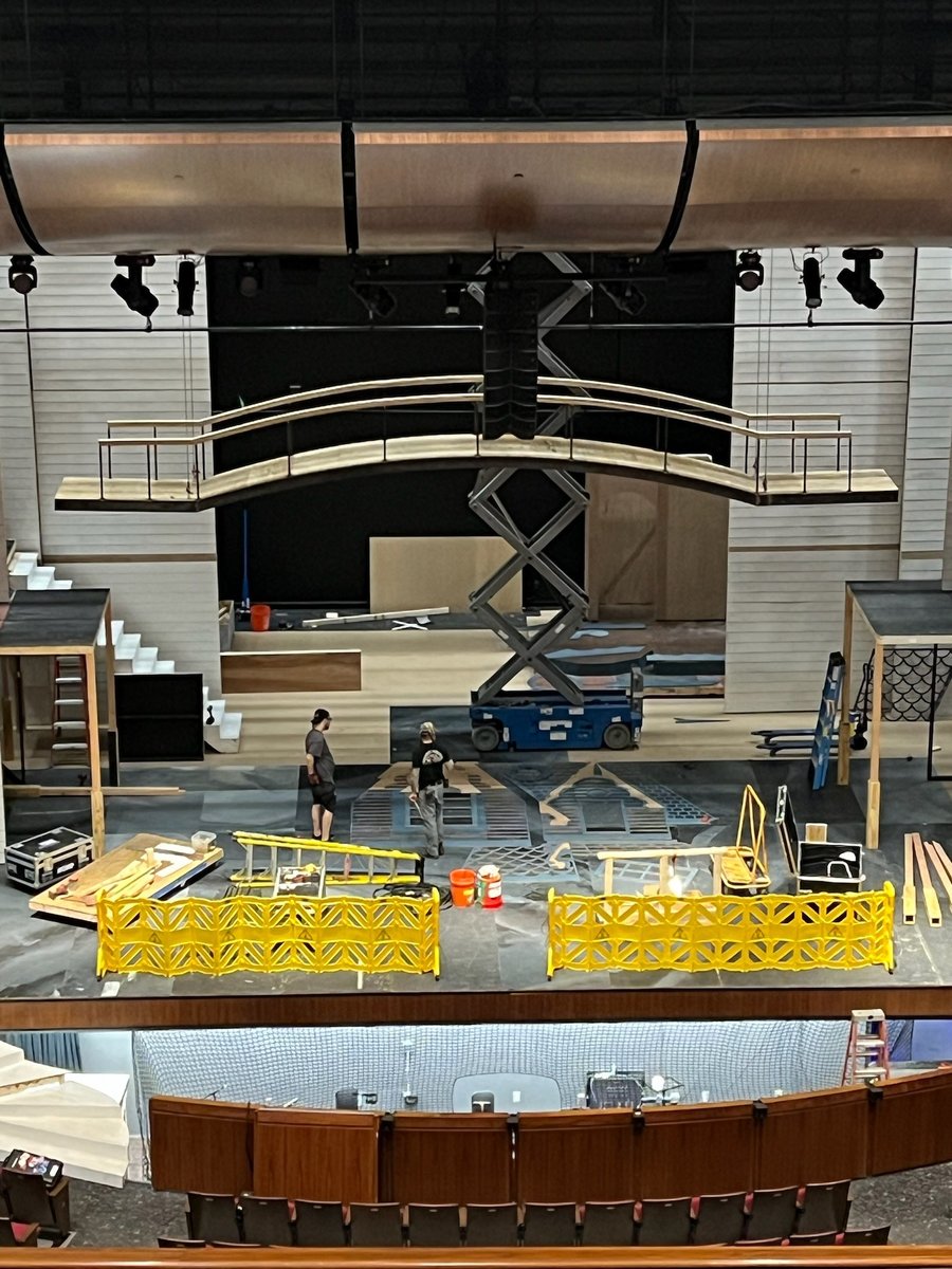 The stage mid-build during load-in, with a scissor lift and scaffolding.