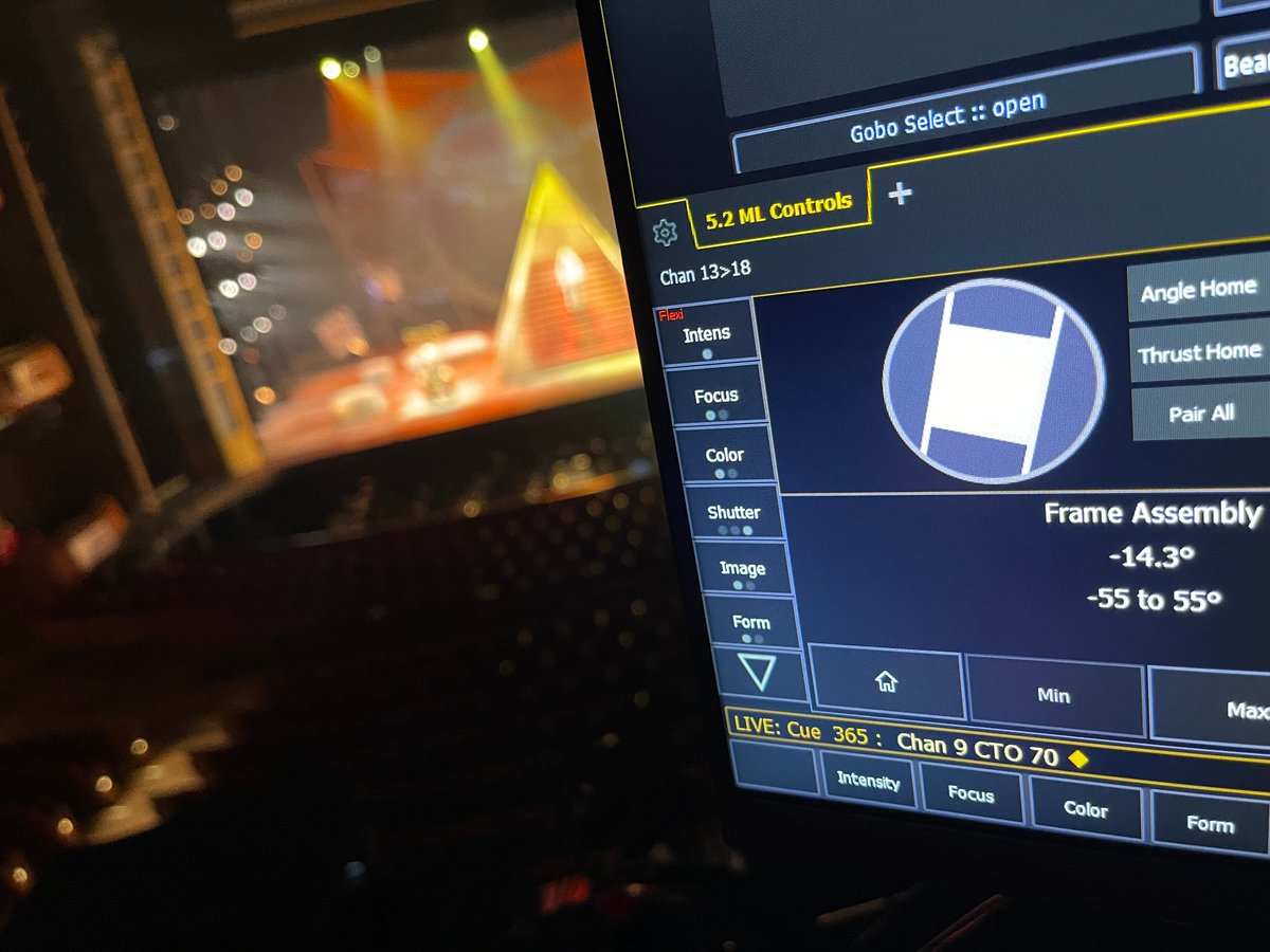 Eos magic sheet detail showing ML Controls and Frame Assembly, with the pyramid revolve set blurred through the booth window in the background