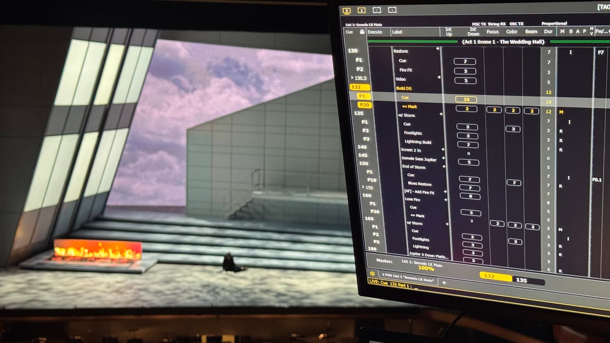 Close-up of the Eos cue list display showing Act I Scene I 'The Wedding Hall' with cues for Restore, Build DS, Lightning, Storm, and other moments, with the stage visible in the background