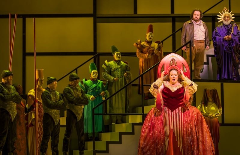 Angela Meade as Princess Turandot in a red gown, center, with the chorus on the Mondrian-inspired geometric staircase set in The Atlanta Opera production of Turandot