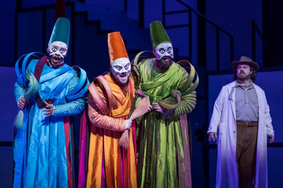 Ping, Pang, and Pong, the three court ministers in vivid blue, orange, and green silk robes and tall masks, beside Prince Calaf in The Atlanta Opera production of Puccini's Turandot