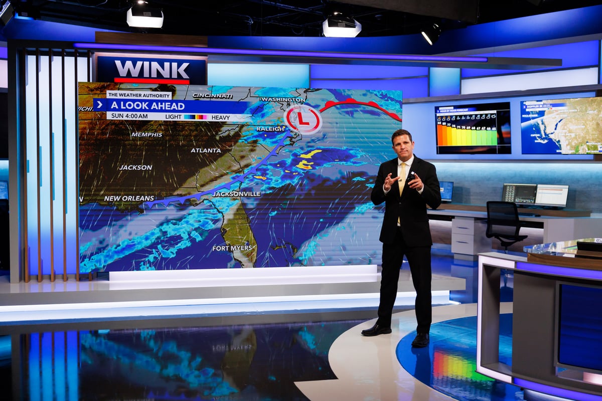 WINK News meteorologist on set in front of the weather wall