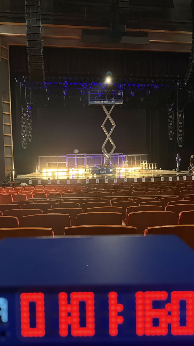 An empty house with the countdown clock before doors, a lift on stage.