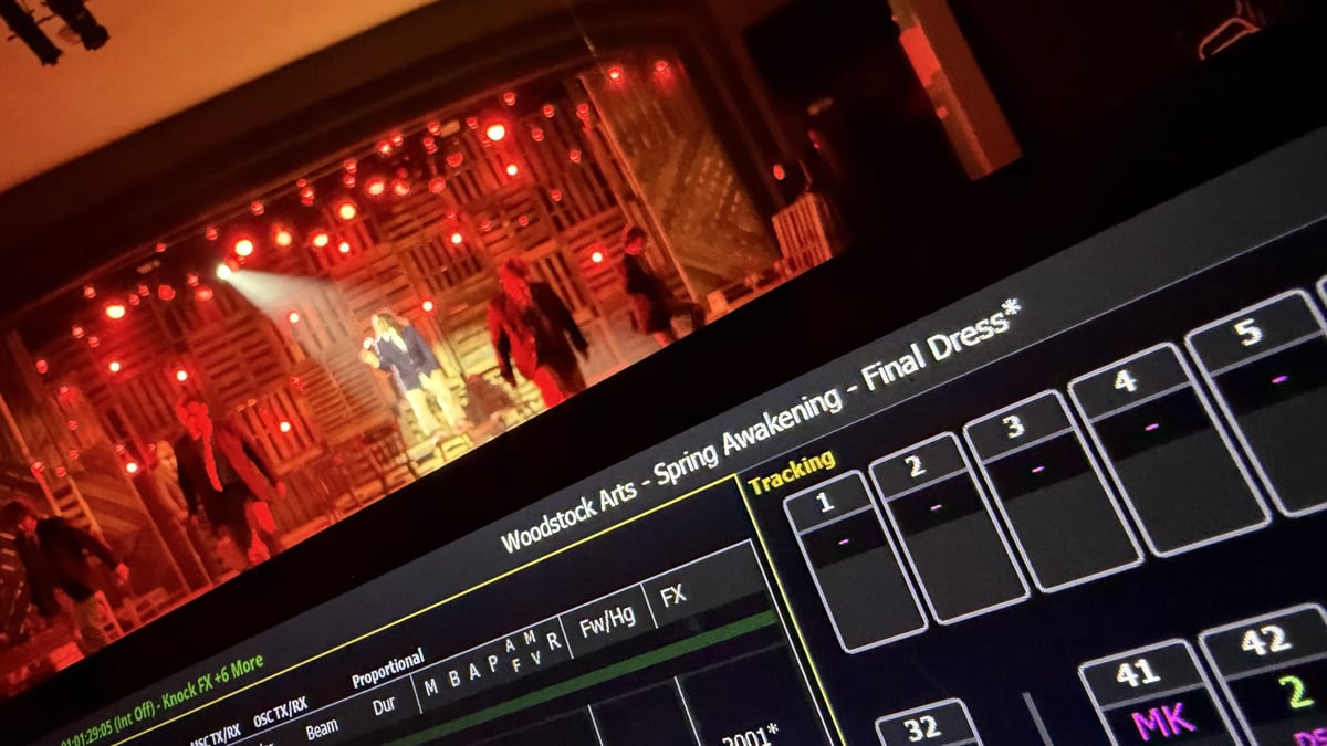 Close on the Eos programming screen labeled Woodstock Arts, Spring Awakening, Final Dress beside a stage feed of a red-lit number