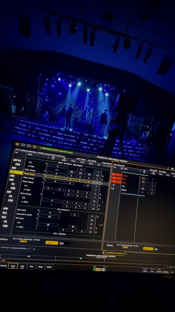 The Eos cue list on the programming screen during final dress, the blue-lit stage visible above the console